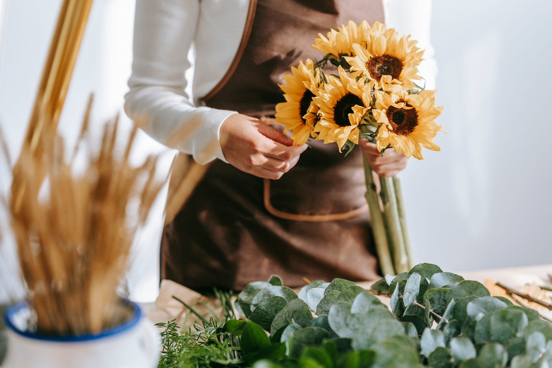 Florist with bouquet of fresh lush sunflowers